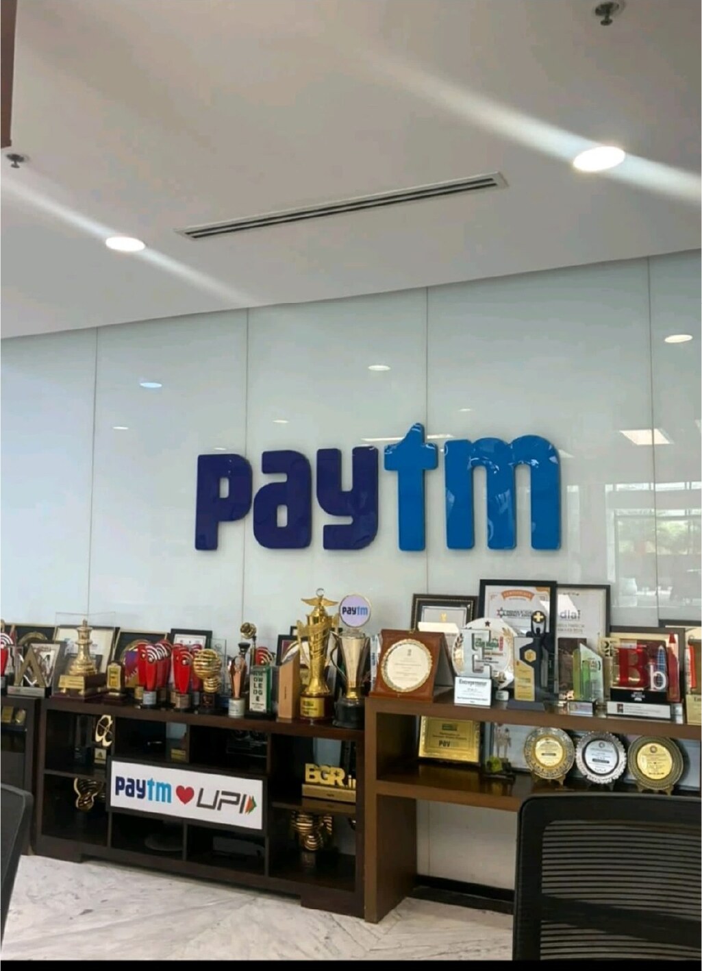 Paytm office wall with logo and award shelf